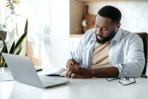 A man reading how to choose an online broker on the Nigerian Stock Market on tradestrek blog